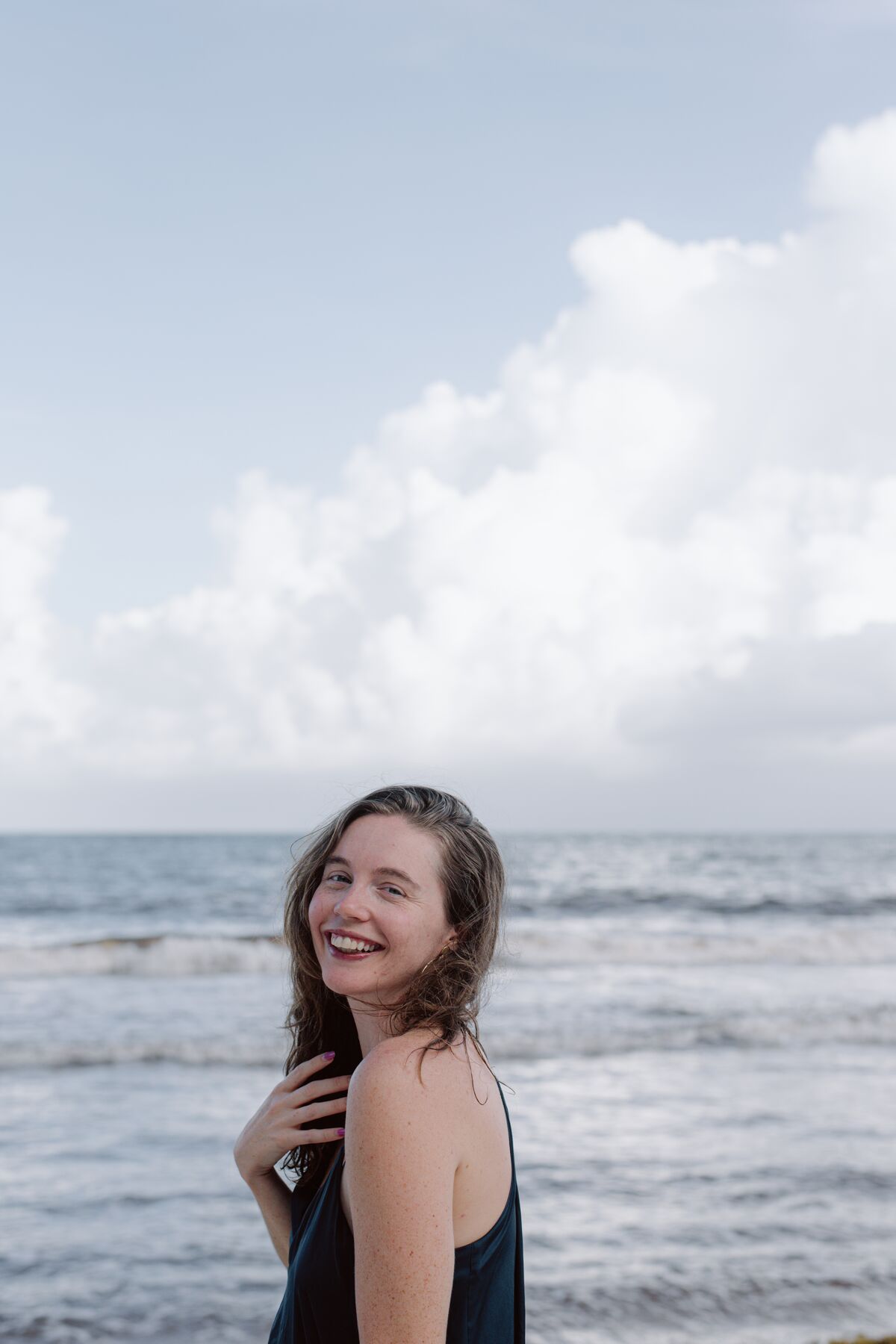 Woman laughing at the edge of the ocean